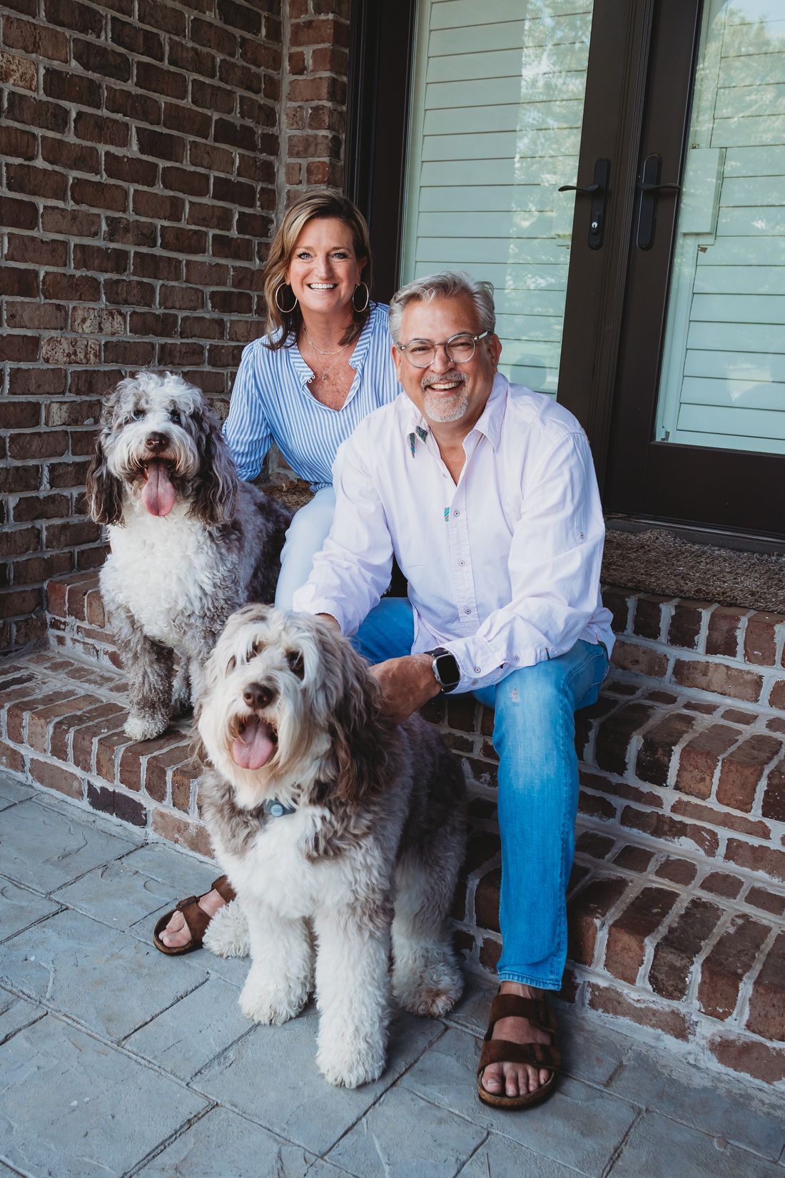 Steve and Melissa Fultz on their porch steps with their two dogs